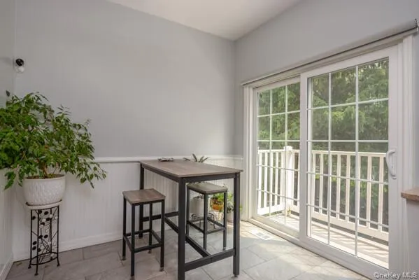 Sliding glass door with grid panes opening to the stairs down to the patio. Sliding glass door with grid panes opening to the stairs down to the patio.