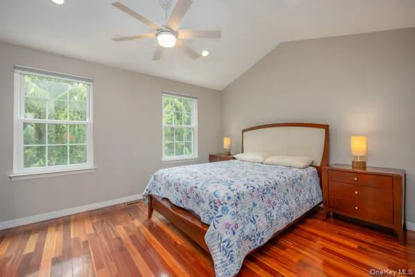 Vaulted ceiling with a ceiling fan, recessed lighting, two double-hung windows, and wood-finish flooring Vaulted ceiling with a ceiling fan, recessed lighting, two double-hung windows, and wood-finish flooring