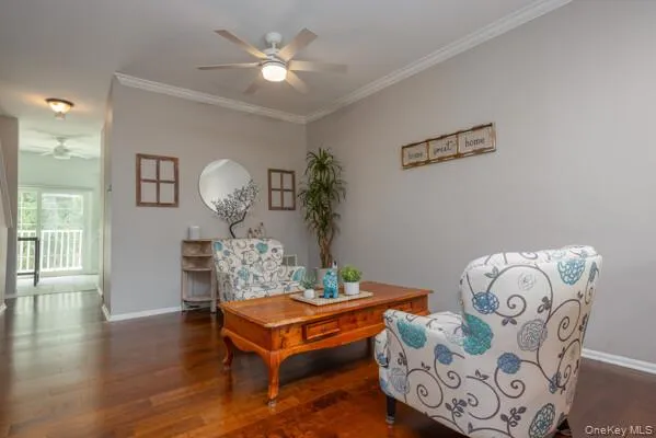 Spacious interior featuring wood-finish flooring, light grey walls, and white crown molding Spacious interior featuring wood-finish flooring, light grey walls, and white crown molding