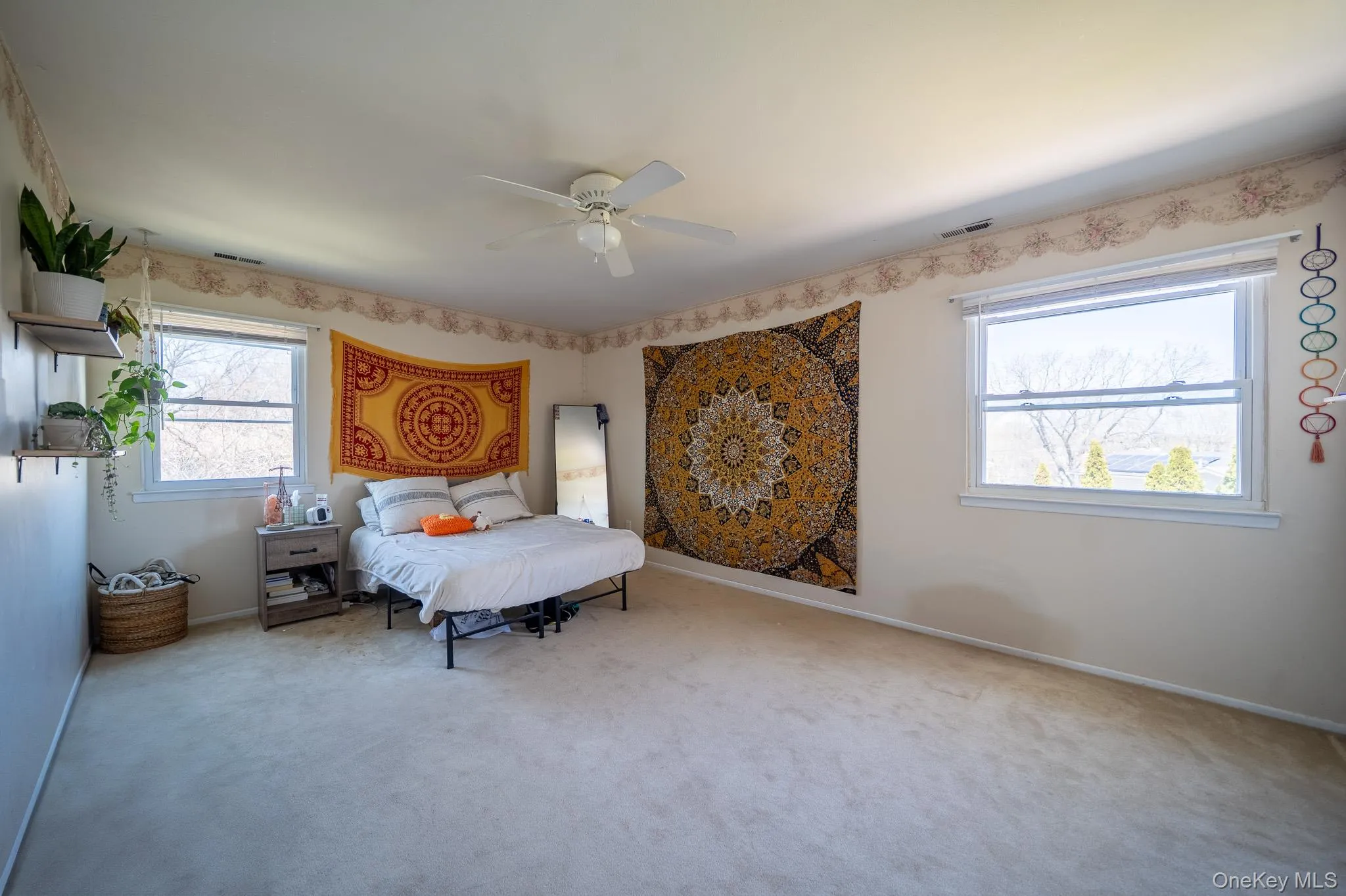 Bedroom featuring carpet floors, a ceiling fan, visible vents, and baseboards Bedroom featuring carpet floors, a ceiling fan, visible vents, and baseboards