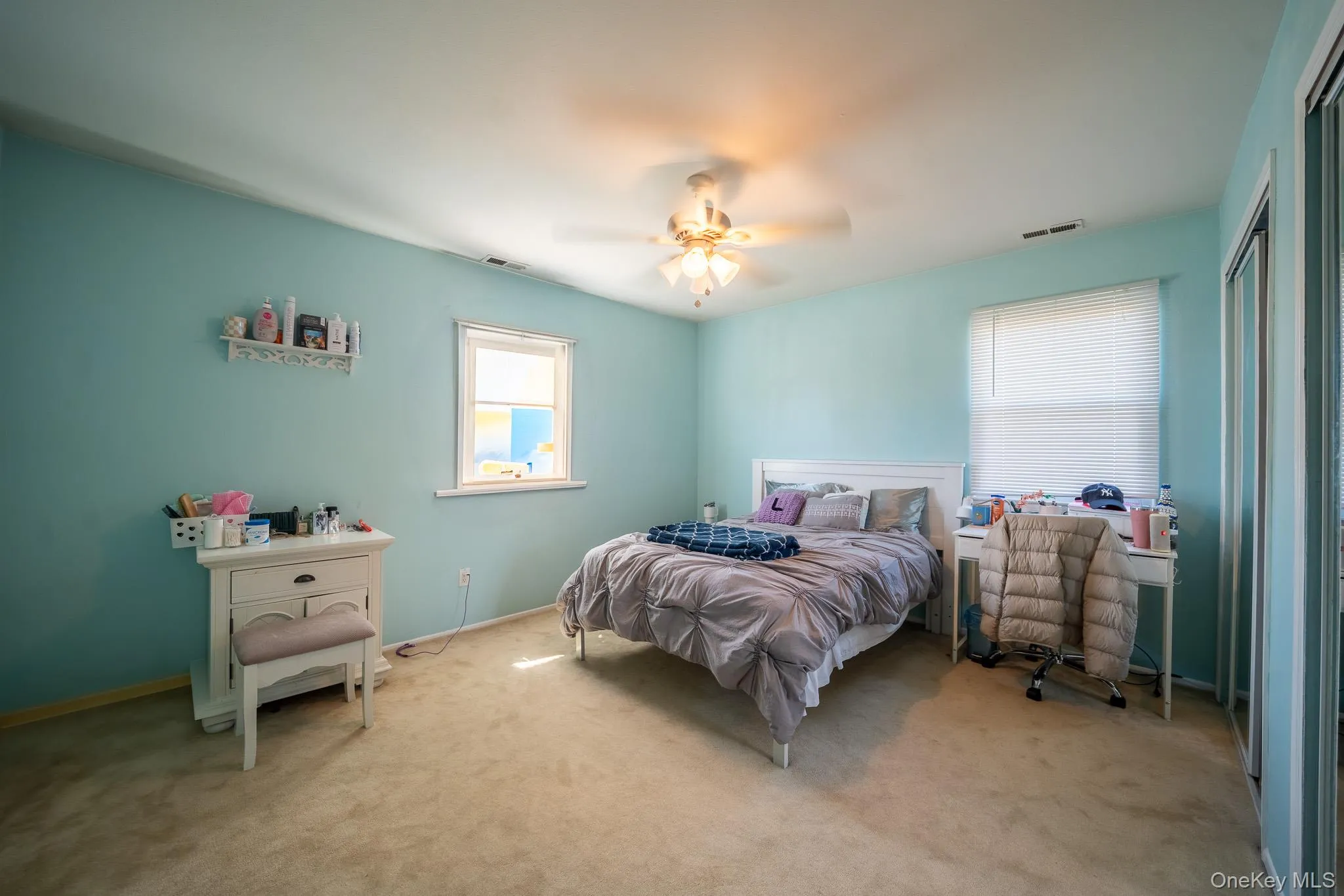 Bedroom featuring carpet floors, multiple windows, and visible vents Bedroom featuring carpet floors, multiple windows, and visible vents
