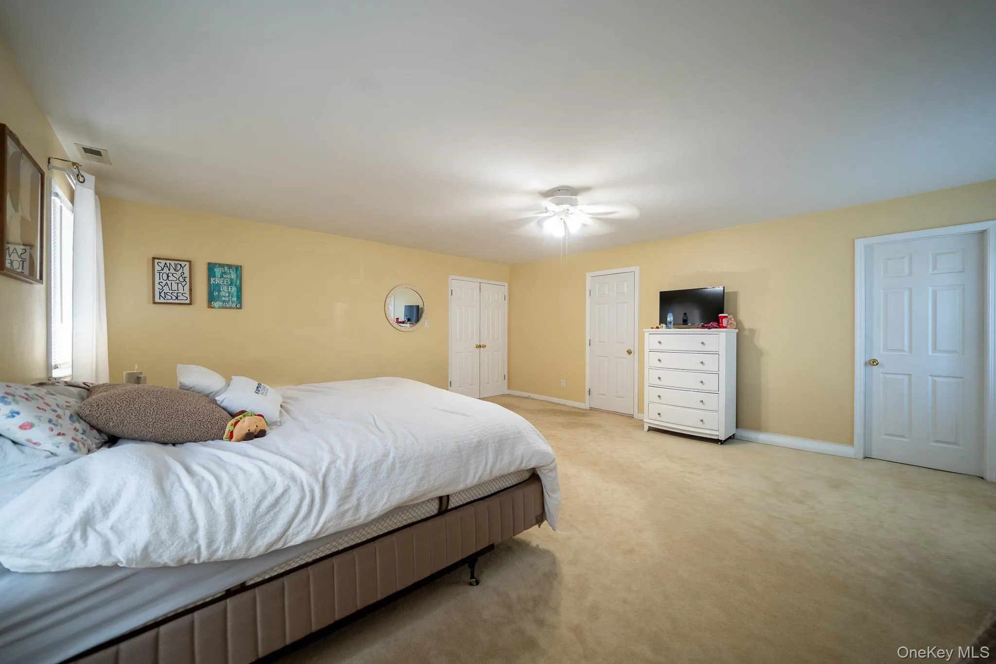 Bedroom featuring baseboards, visible vents, light colored carpet, and ceiling fan Bedroom featuring baseboards, visible vents, light colored carpet, and ceiling fan