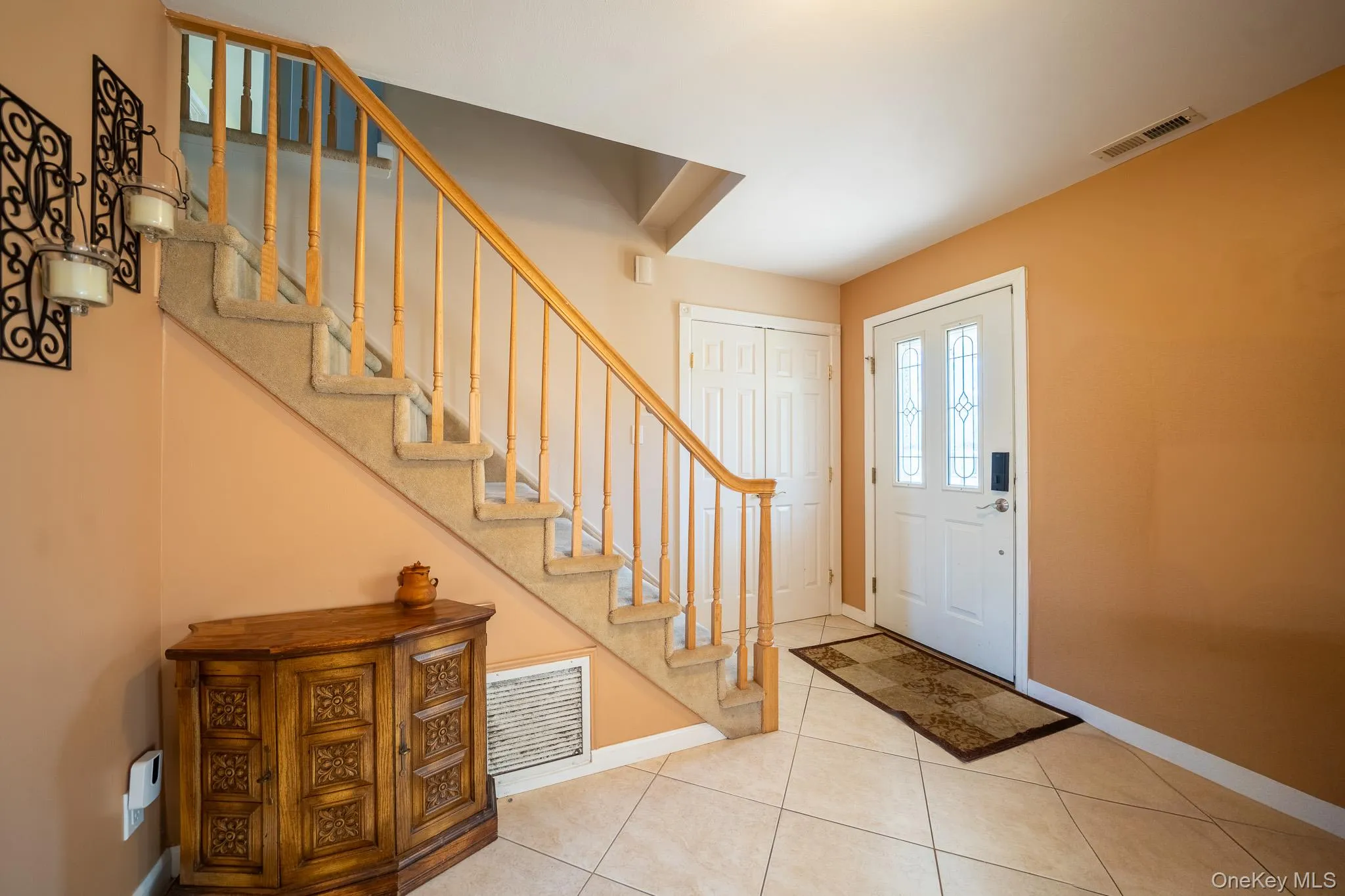 Foyer featuring baseboards, visible vents, tile patterned flooring, and stairs Foyer featuring baseboards, visible vents, tile patterned flooring, and stairs