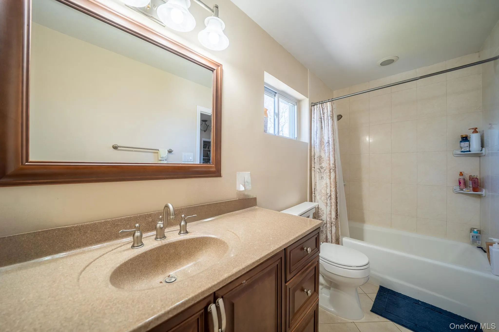 Full bath featuring tile patterned flooring, toilet, vanity, and shower / bath combo Full bath featuring tile patterned flooring, toilet, vanity, and shower / bath combo