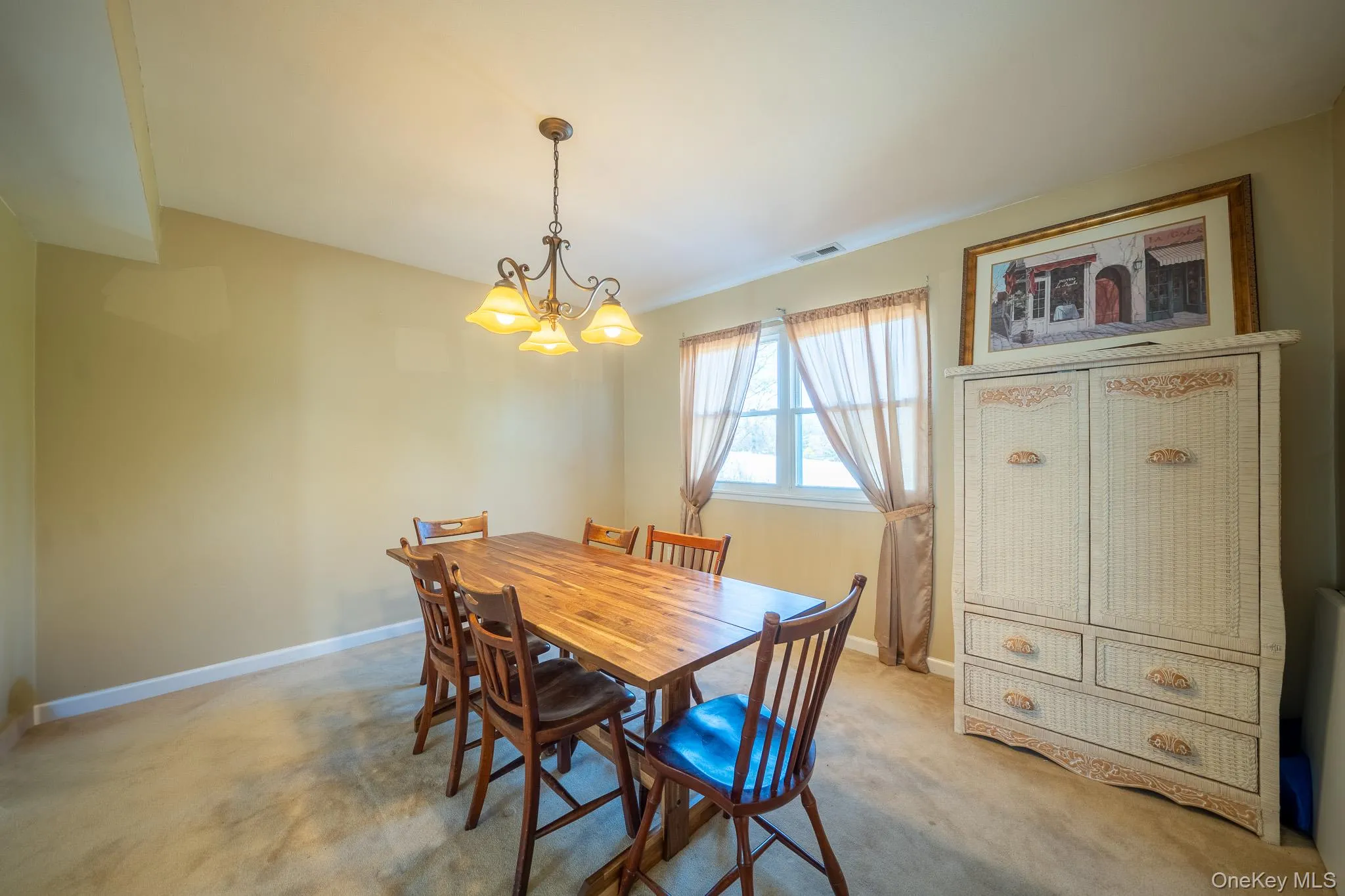 Dining area with carpet, visible vents, baseboards, and a notable chandelier Dining area with carpet, visible vents, baseboards, and a notable chandelier