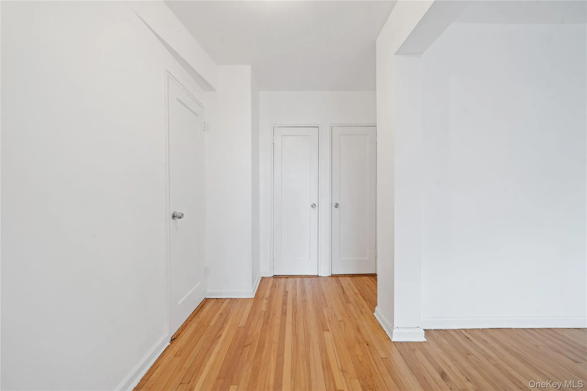 Wood-finish flooring throughout, bright white walls, and flush-mounted ceiling lighting Wood-finish flooring throughout, bright white walls, and flush-mounted ceiling lighting
