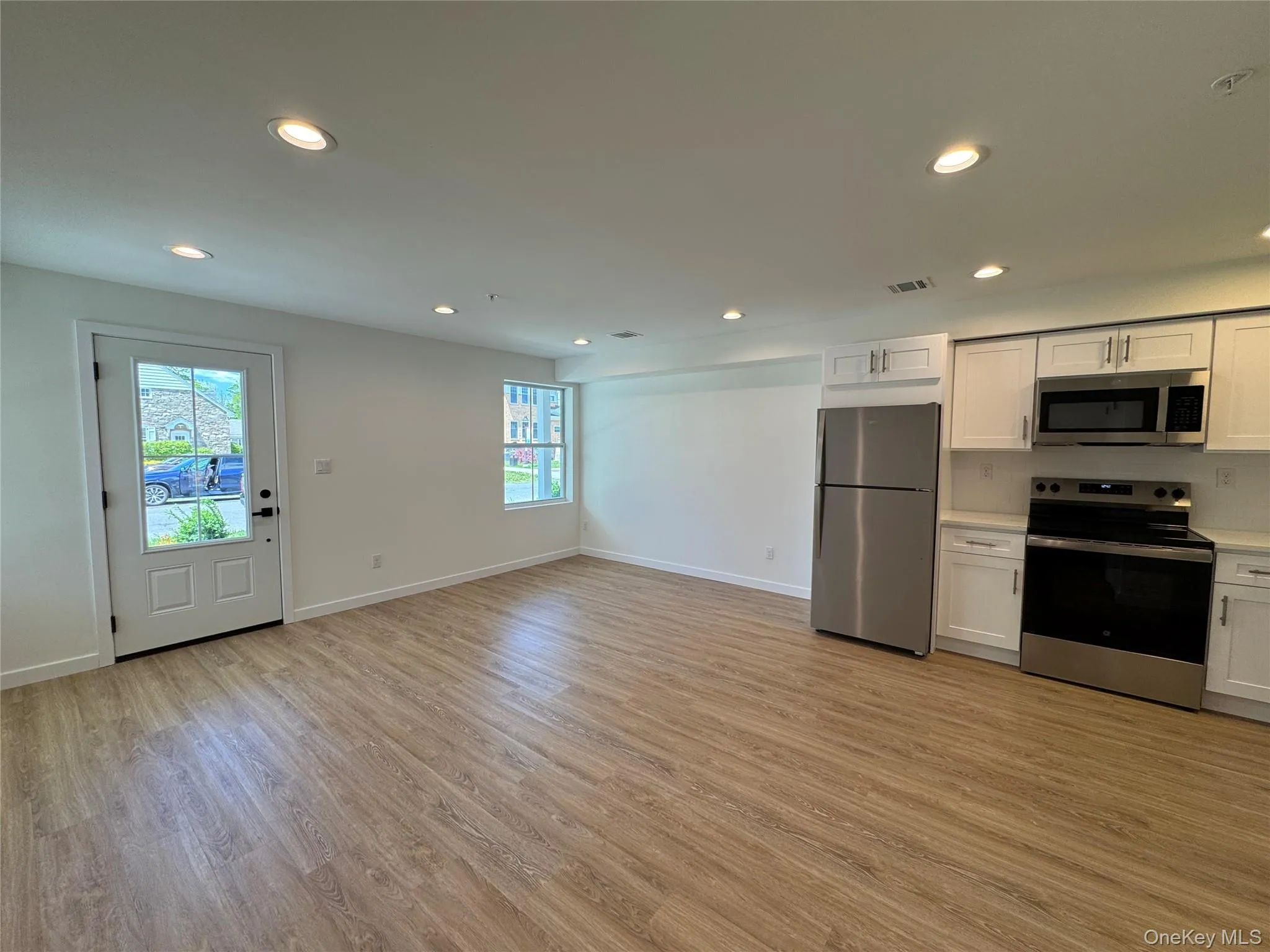 Kitchen with stainless steel appliances, plenty of natural light, light wood-type flooring, and recessed lighting Kitchen with stainless steel appliances, plenty of natural light, light wood-type flooring, and recessed lighting