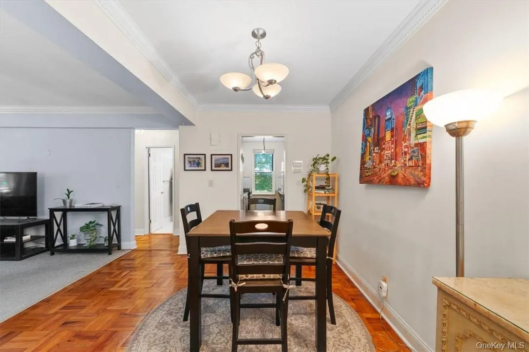 Dining room with a chandelier, parquet flooring, and ornamental molding Dining room with a chandelier, parquet flooring, and ornamental molding