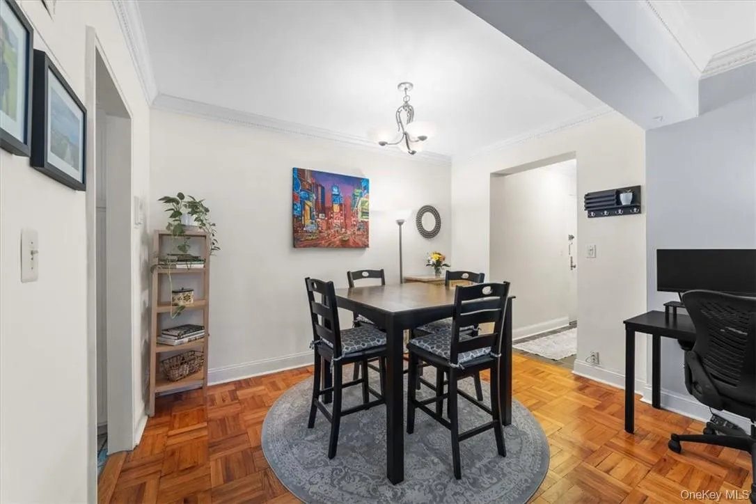 Dining area featuring a notable chandelier, parquet flooring, and ornamental molding Dining area featuring a notable chandelier, parquet flooring, and ornamental molding