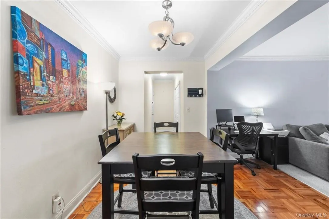 Dining area with an inviting chandelier, crown molding, and parquet floors Dining area with an inviting chandelier, crown molding, and parquet floors