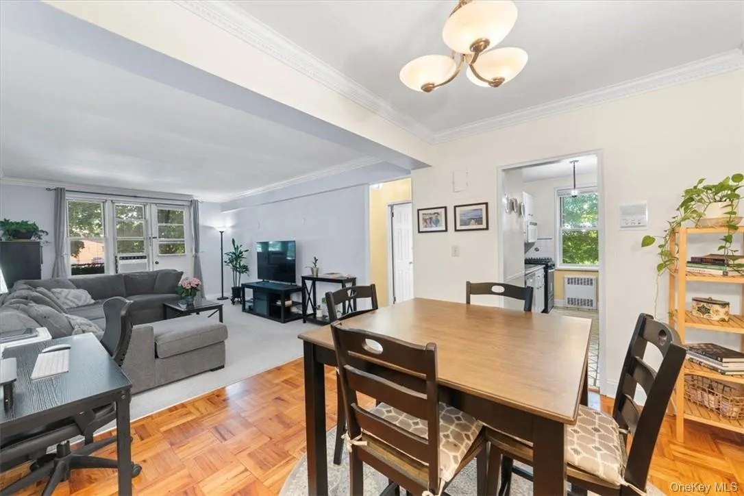 Dining room with light parquet floors, radiator, crown molding, and plenty of natural light Dining room with light parquet floors, radiator, crown molding, and plenty of natural light