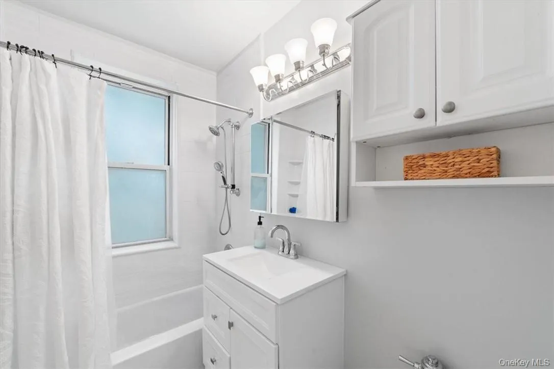 Bathroom featuring vanity and shower / bath combo with shower curtain Bathroom featuring vanity and shower / bath combo with shower curtain