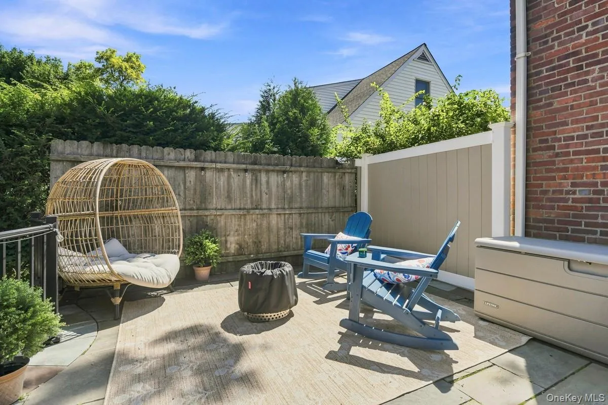 Paved patio area featuring a privacy fence, brick exterior wall, and established perimeter hedging. Paved patio area featuring a privacy fence, brick exterior wall, and established perimeter hedging.