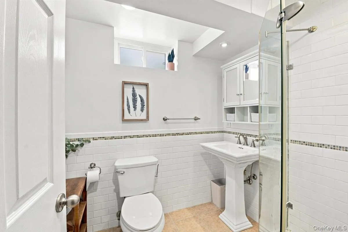 Second full bathroom with classic white subway tile and a mosaic accent border. Second full bathroom with classic white subway tile and a mosaic accent border.