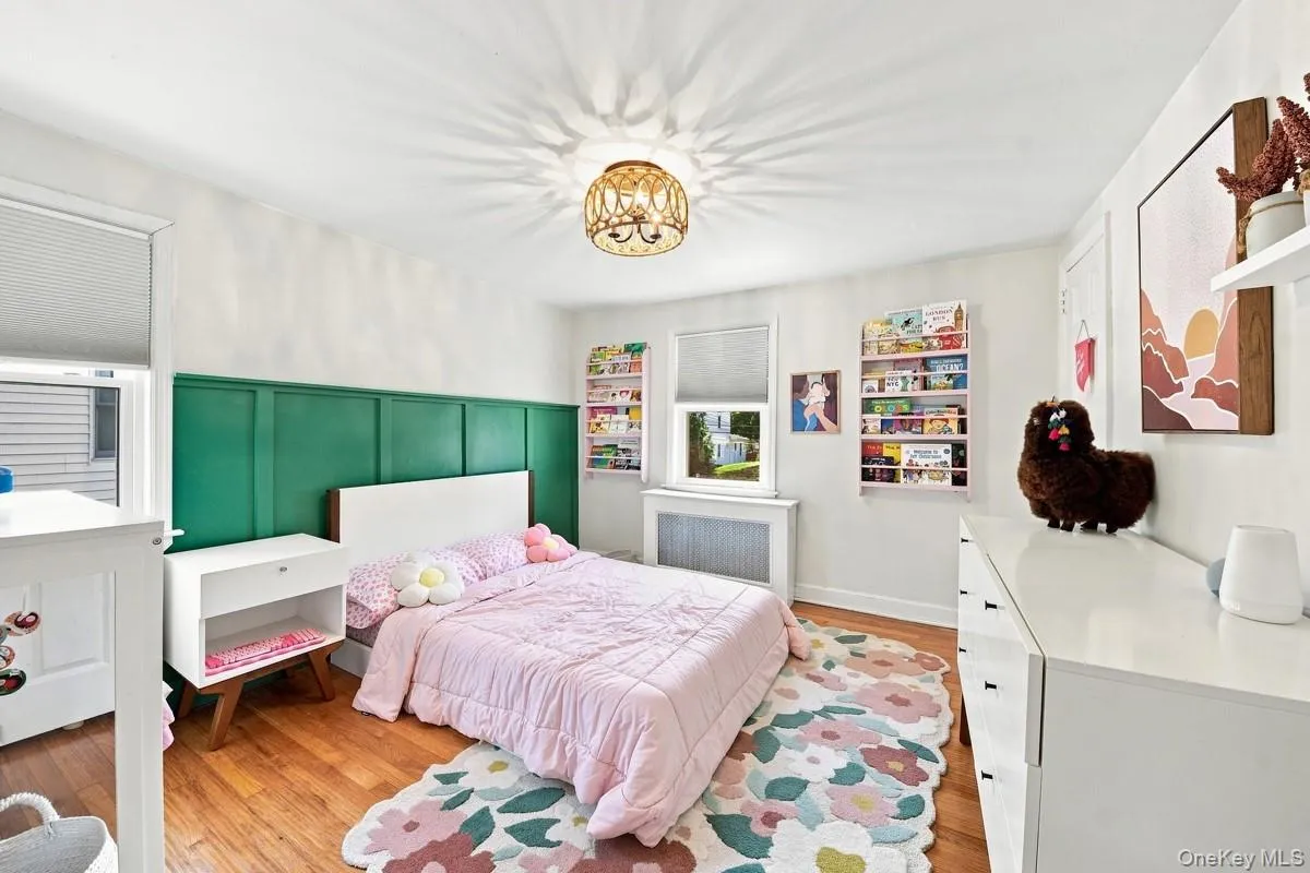 Third Bedroom. Hardwood flooring, board and batten wall accent, and a decorative ceiling light fixture. Third Bedroom. Hardwood flooring, board and batten wall accent, and a decorative ceiling light fixture.