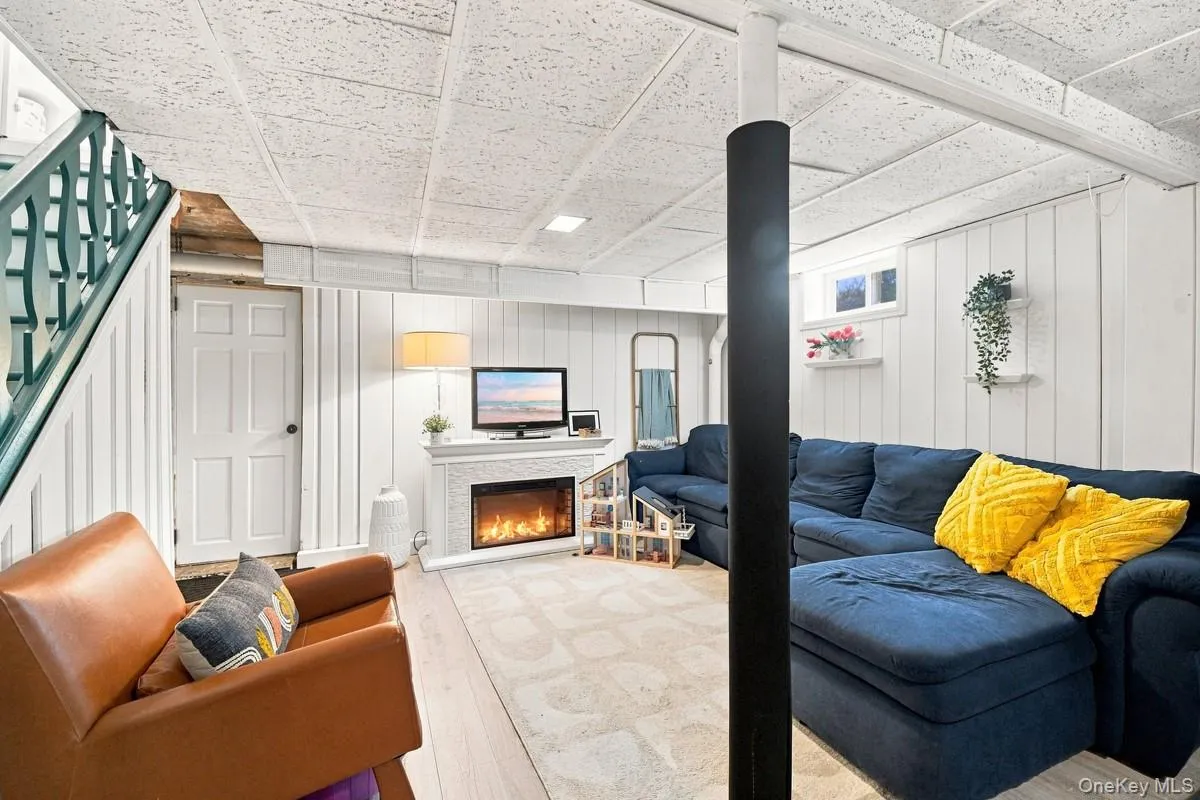Finished lower level with wood-look laminate flooring, egress door to the backyard and patio, and a decorative fireplace (excluded from sale). Finished lower level with wood-look laminate flooring, egress door to the backyard and patio, and a decorative fireplace (excluded from sale).