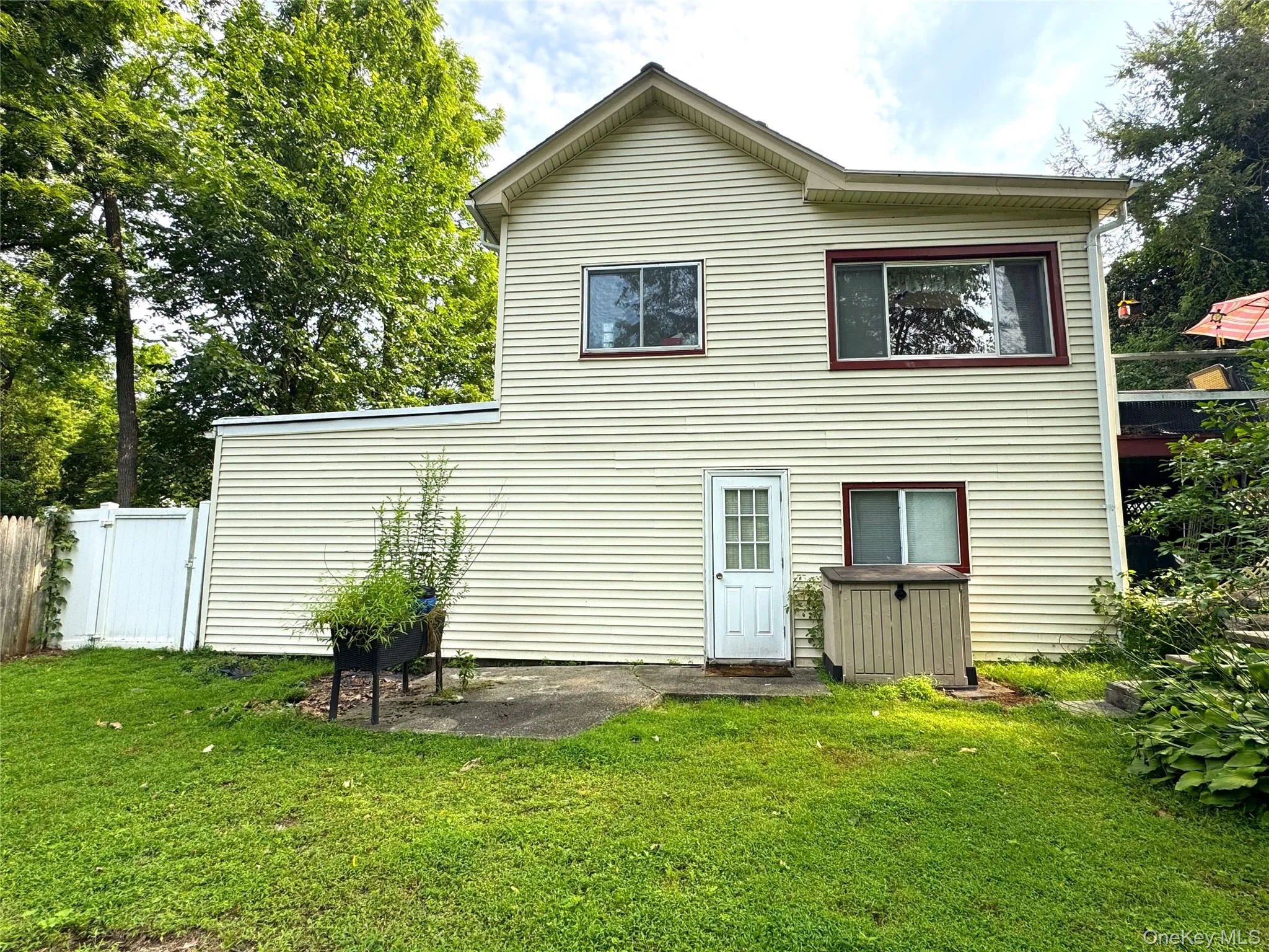 Exterior siding with multiple window styles, established trees, and a green lawn Exterior siding with multiple window styles, established trees, and a green lawn