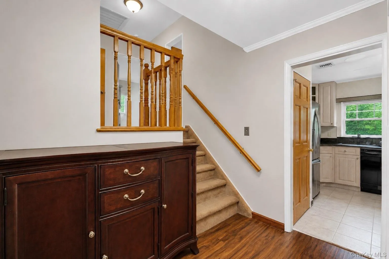 Wood-finish flooring and a staircase with carpeted treads Wood-finish flooring and a staircase with carpeted treads
