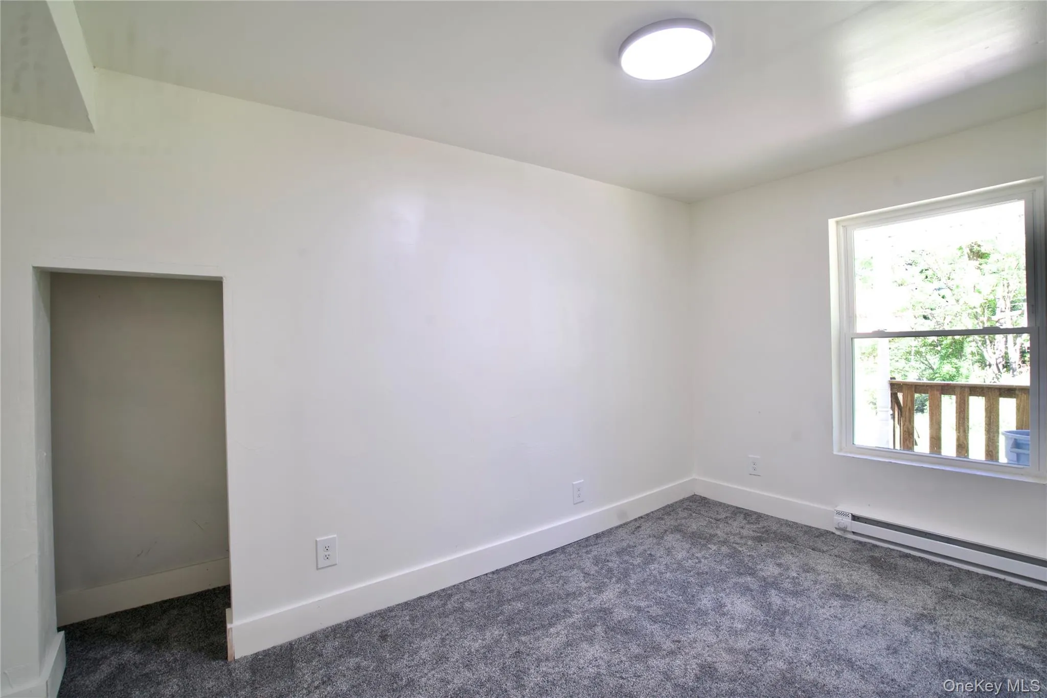 Unfurnished room featuring dark carpet and baseboards Unfurnished room featuring dark carpet and baseboards