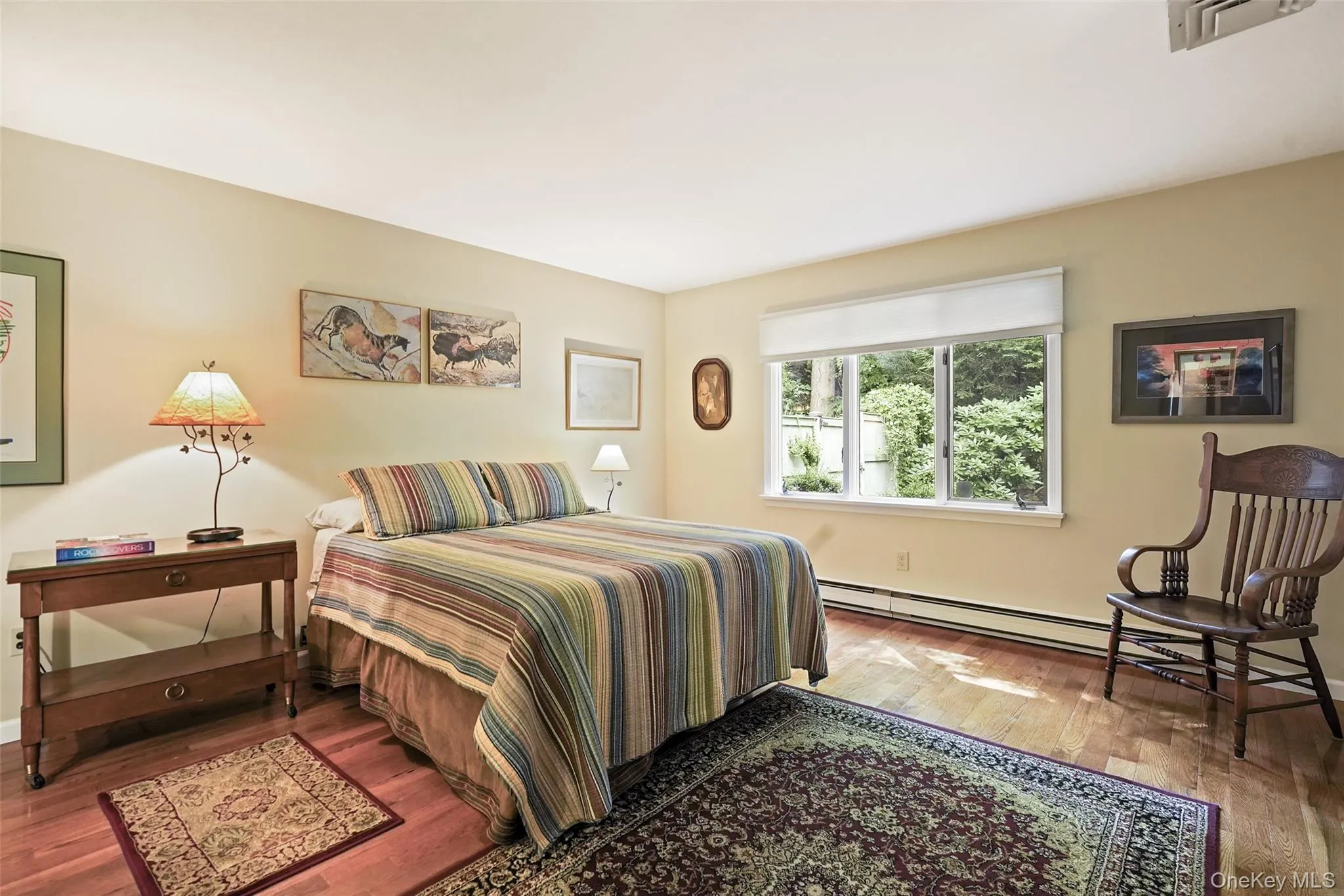 Spacious primary bedroom with window facing private backyard Spacious primary bedroom with window facing private backyard