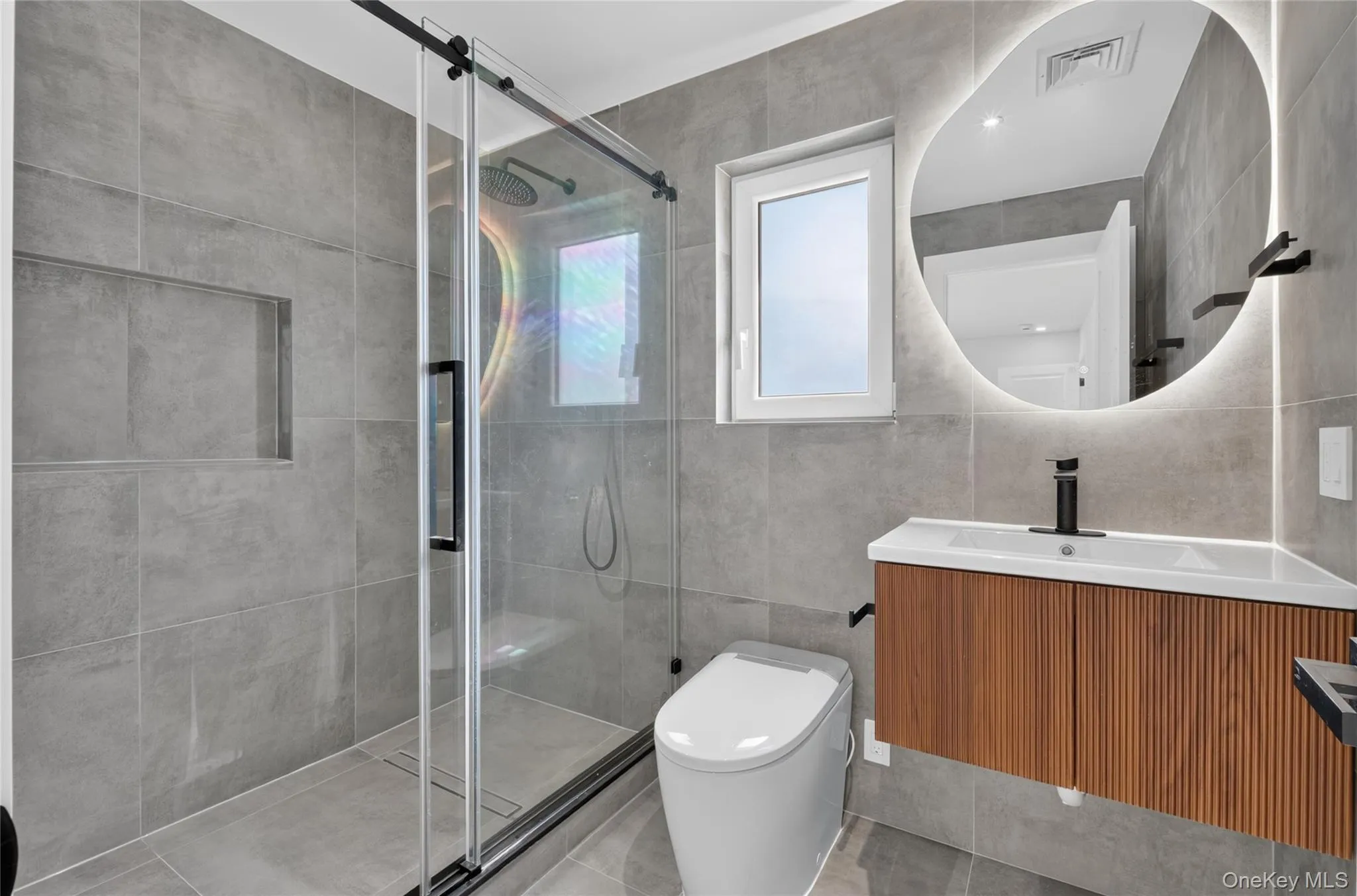 Shower with glass sliding door, built-in shower niche, and rain shower head Shower with glass sliding door, built-in shower niche, and rain shower head