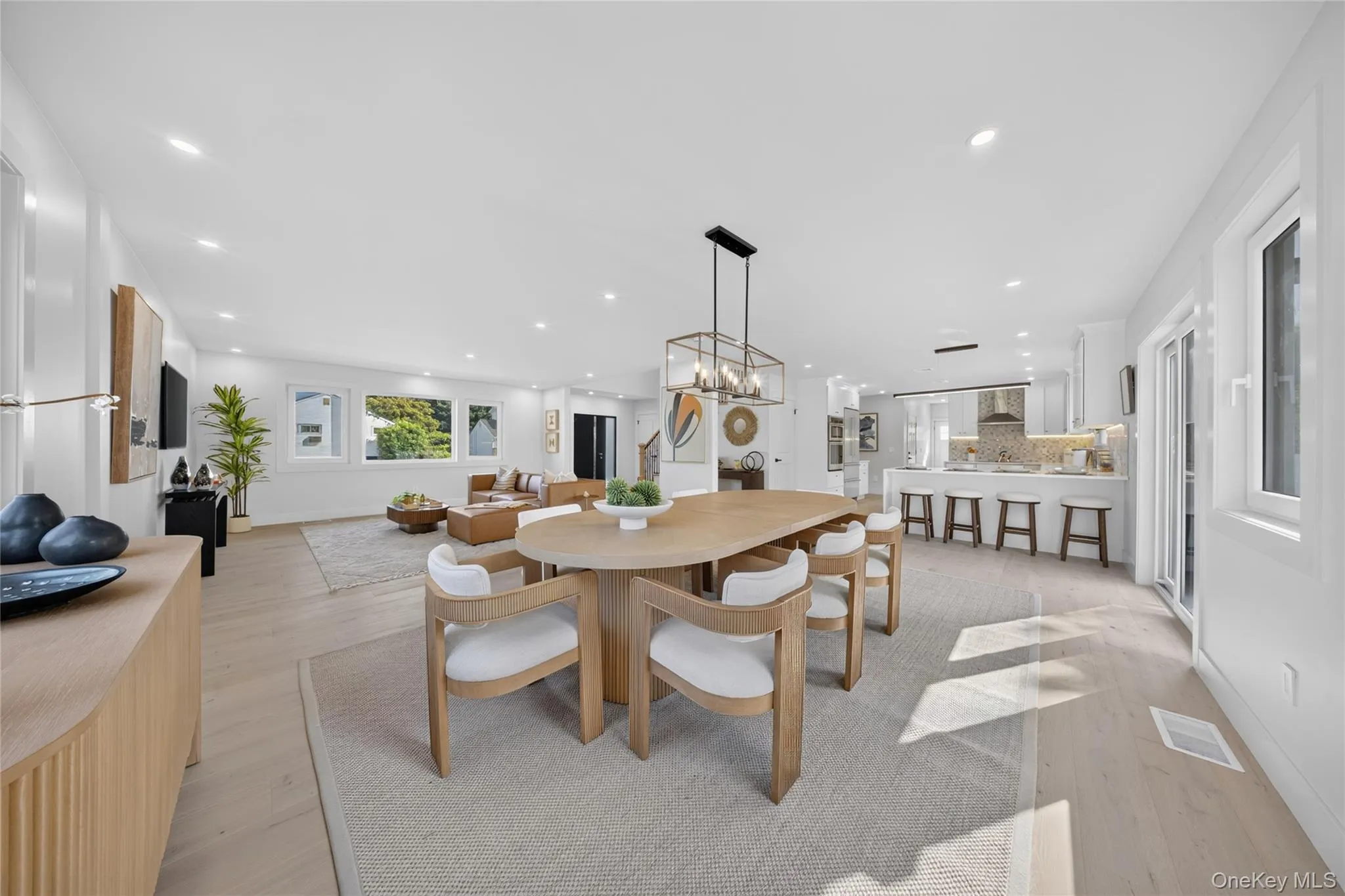 Open-concept living space featuring light wood-finish flooring, recessed lighting, and white walls Open-concept living space featuring light wood-finish flooring, recessed lighting, and white walls