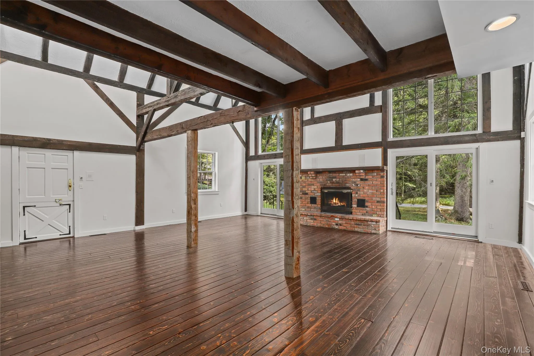 Unfurnished living room featuring a fireplace, high beamed ceiling, and dark wood finished floors. Unfurnished living room featuring a fireplace, high beamed ceiling, and dark wood finished floors.