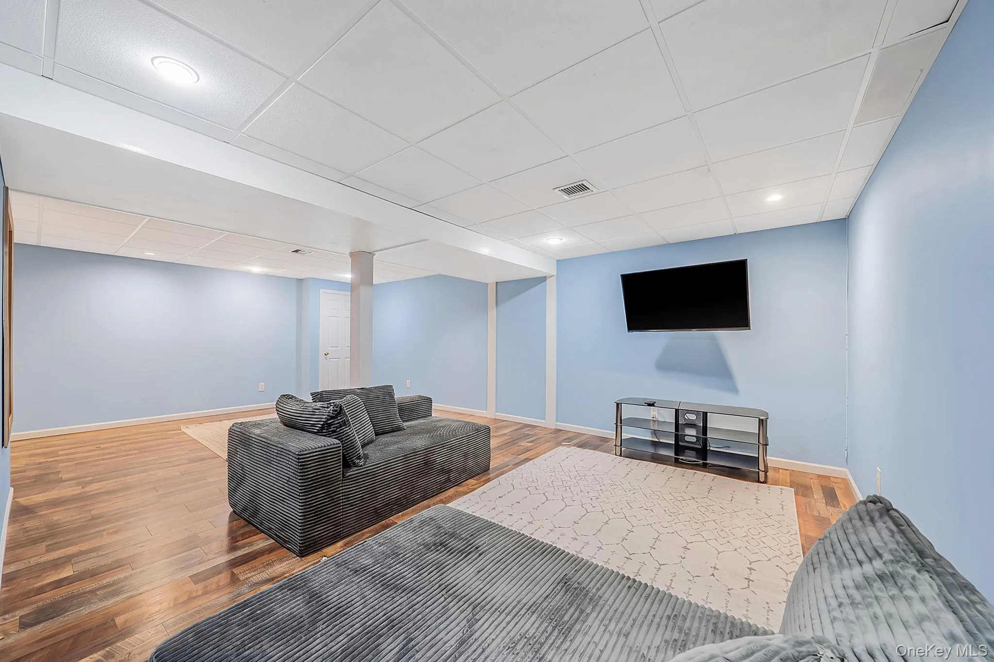 Spacious lower level featuring wood-finish flooring, recessed lighting, and a drop ceiling Spacious lower level featuring wood-finish flooring, recessed lighting, and a drop ceiling