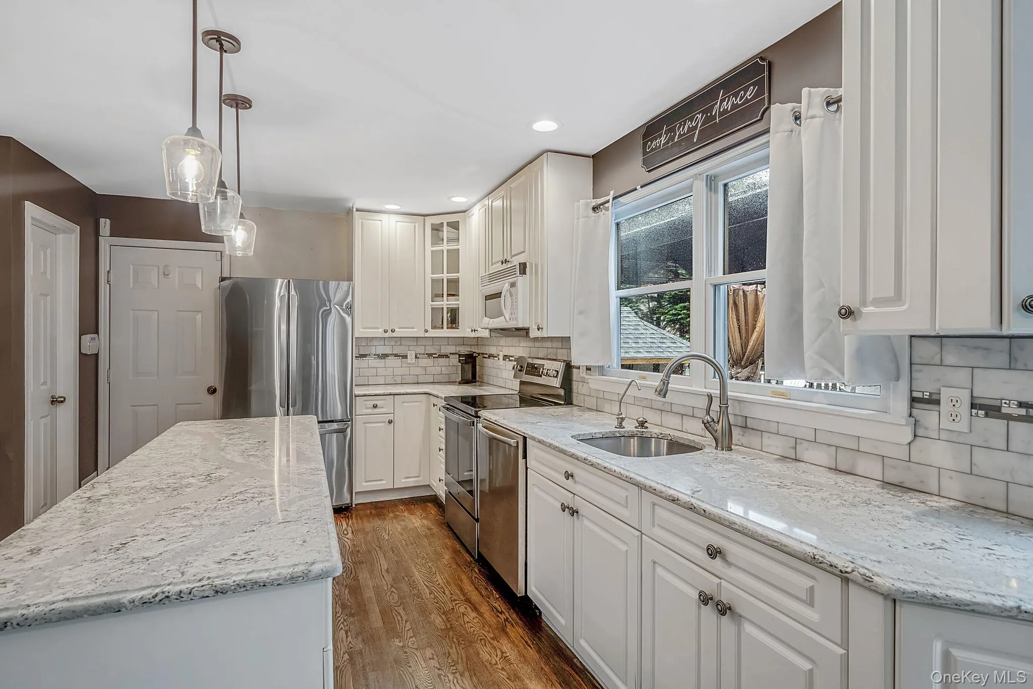 Contemporary kitchen featuring white cabinetry, light-toned countertops, and stainless steel appliances Contemporary kitchen featuring white cabinetry, light-toned countertops, and stainless steel appliances