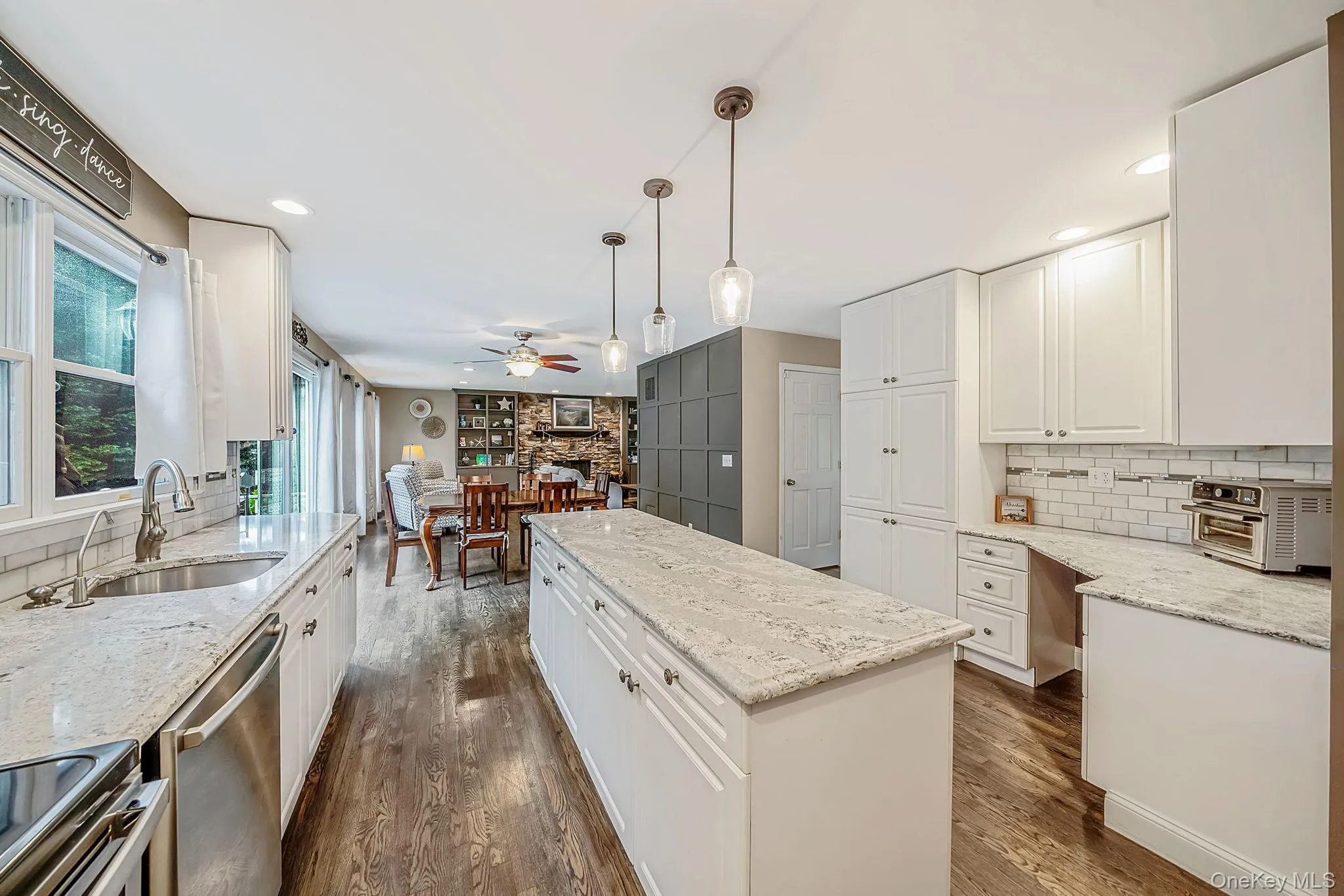 Modern kitchen featuring white cabinetry, light-toned countertops, and hardwood flooring Modern kitchen featuring white cabinetry, light-toned countertops, and hardwood flooring