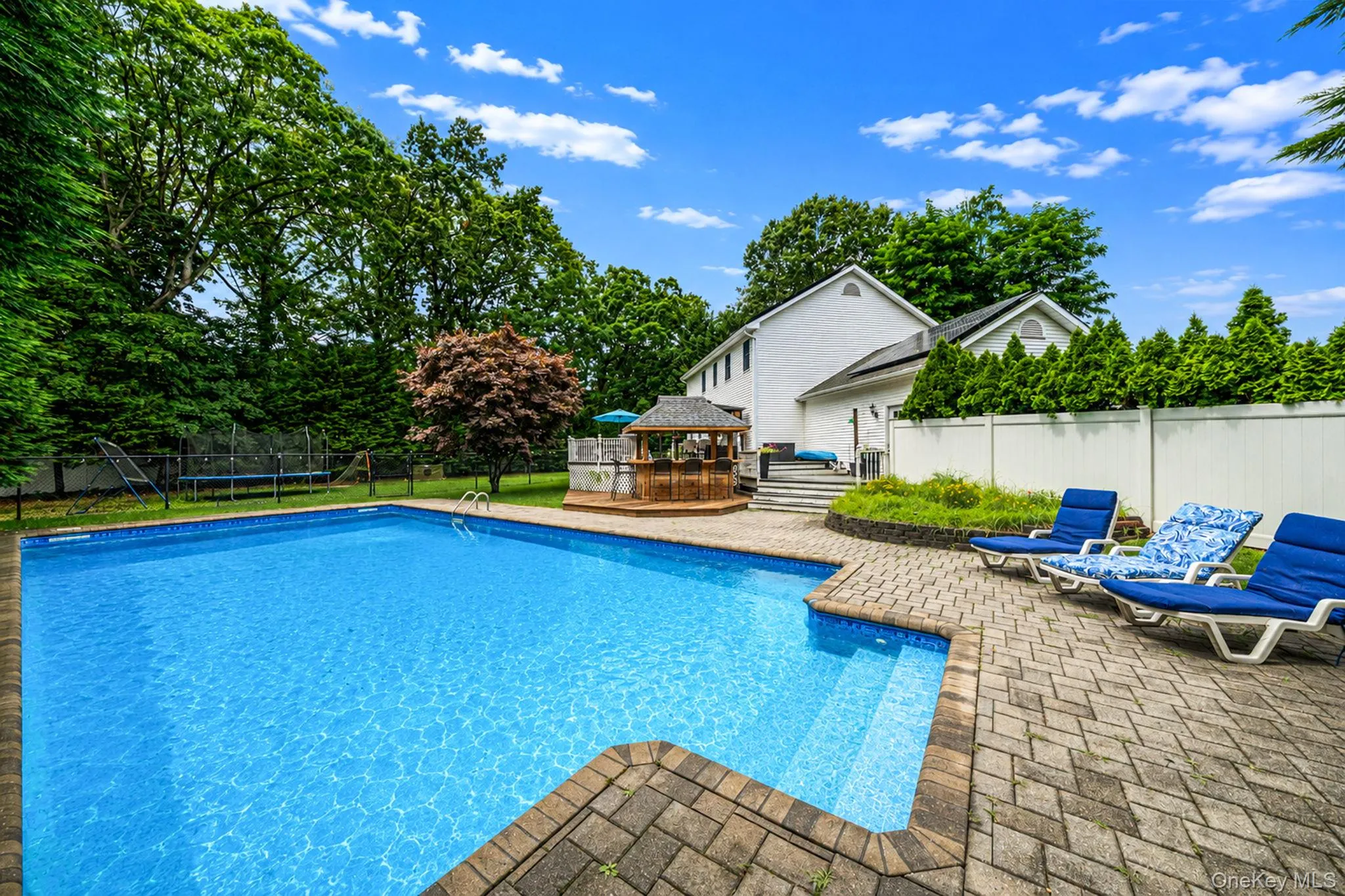 In-ground swimming pool featuring integrated steps and a paver stone surround In-ground swimming pool featuring integrated steps and a paver stone surround