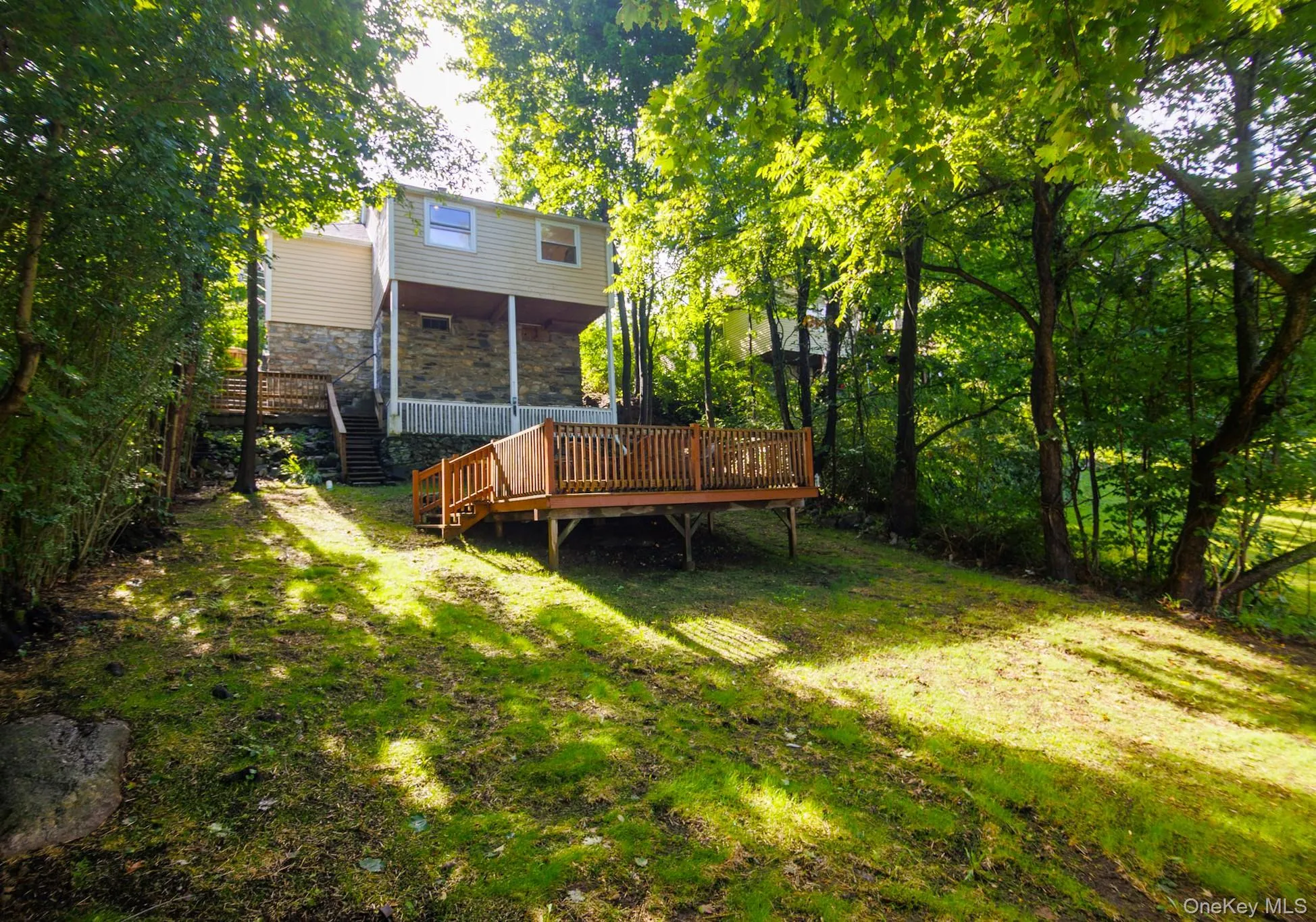 Back yard with covered porch and deck. Newer siding and roof. Back yard with covered porch and deck. Newer siding and roof.