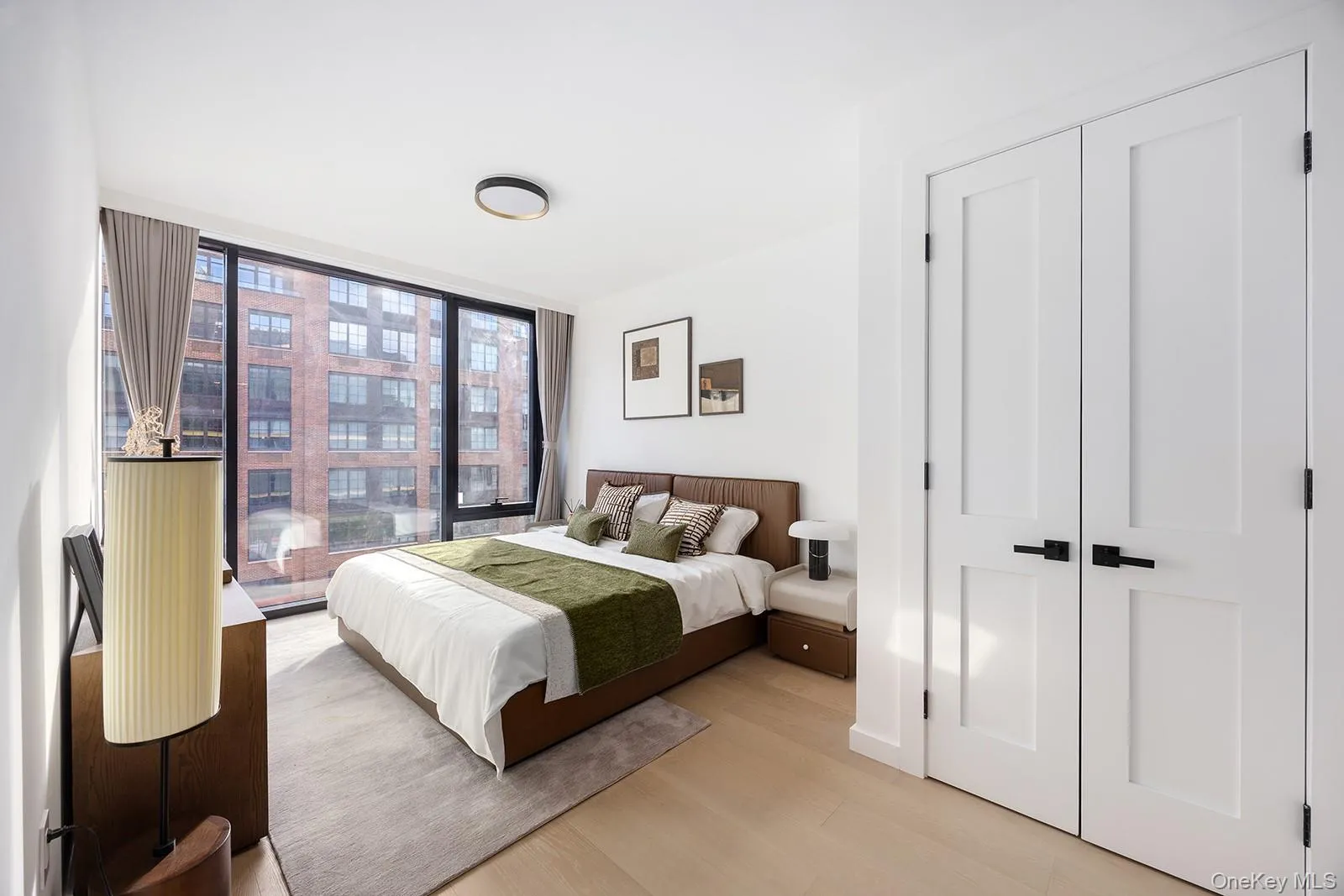 Bedroom featuring wood finished floors, floor to ceiling windows, and a closet Bedroom featuring wood finished floors, floor to ceiling windows, and a closet