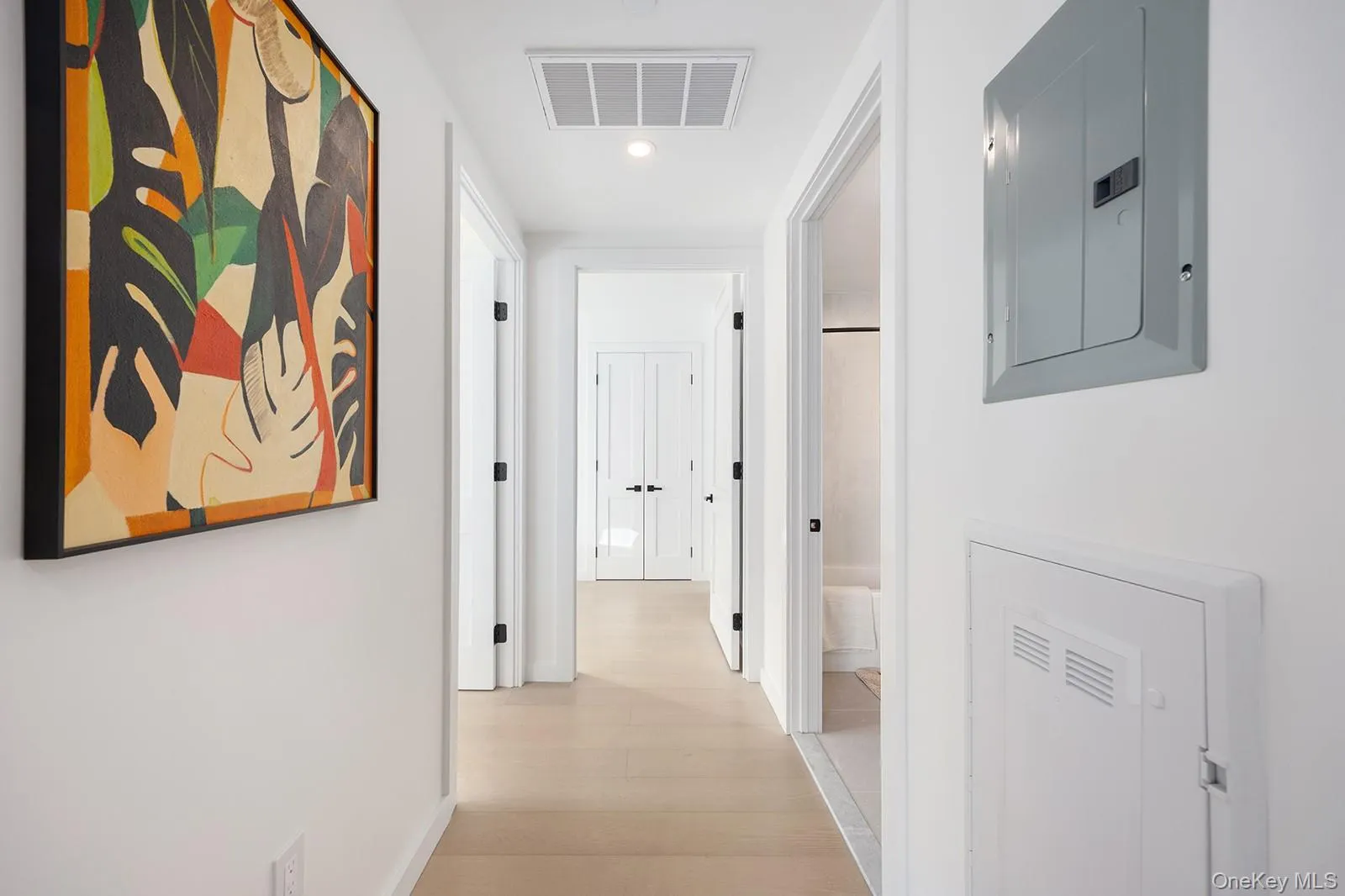 Corridor with electric panel, light wood-type flooring, and recessed lighting Corridor with electric panel, light wood-type flooring, and recessed lighting