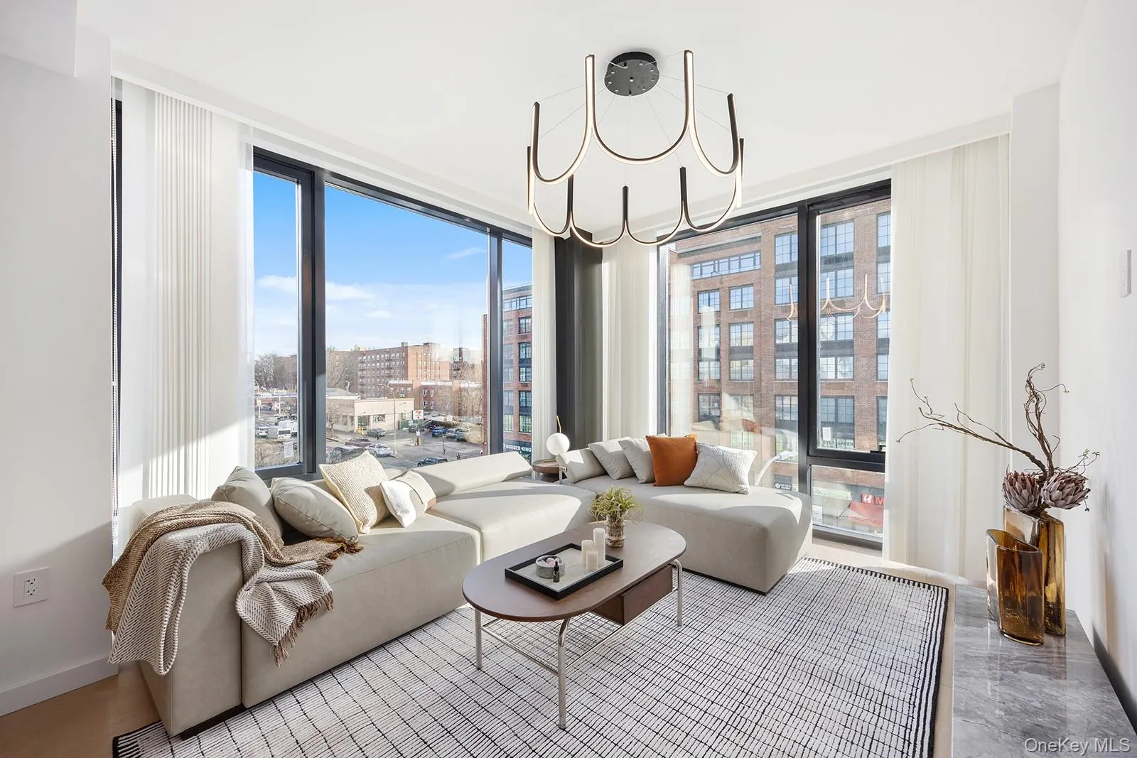 Living room featuring expansive windows, a chandelier, and a city view Living room featuring expansive windows, a chandelier, and a city view