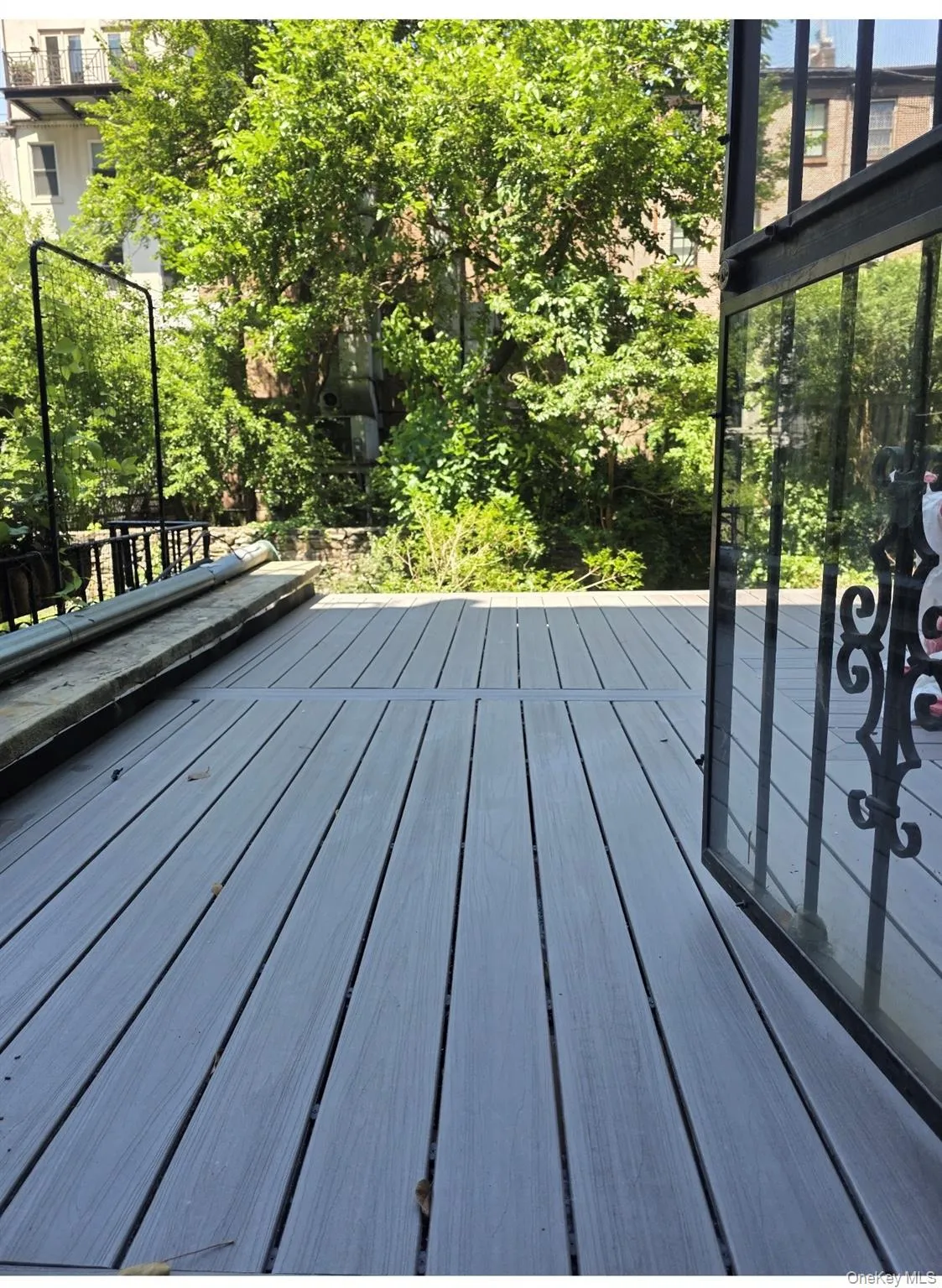 Expansive outdoor decking with composite wood-finish planks and iron railings. 240 square feet. Expansive outdoor decking with composite wood-finish planks and iron railings. 240 square feet.