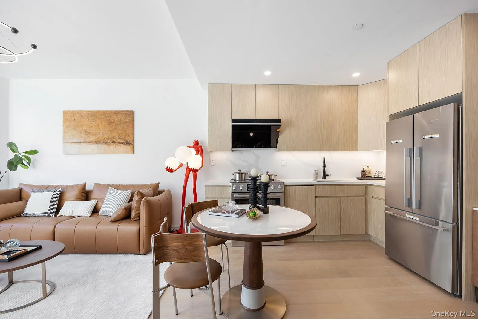 Kitchen with light brown cabinets, modern cabinets, appliances with stainless steel finishes, open floor plan, and decorative backsplash Kitchen with light brown cabinets, modern cabinets, appliances with stainless steel finishes, open floor plan, and decorative backsplash