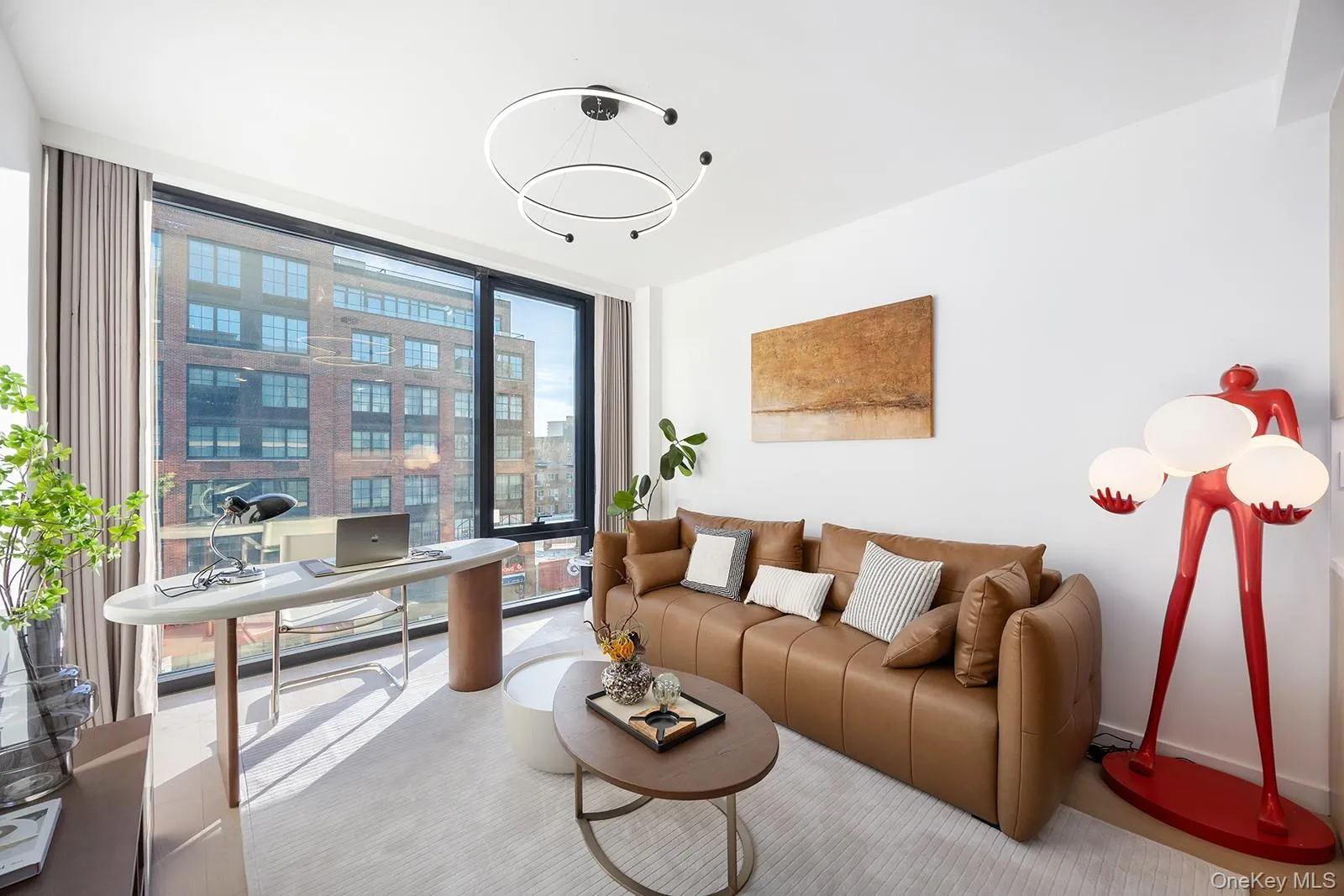 Living area with an office area and a wall of windows Living area with an office area and a wall of windows