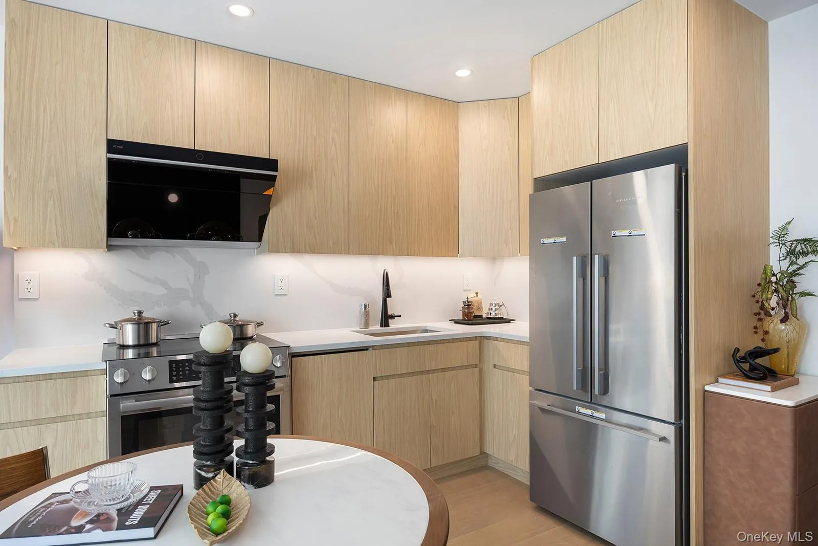 Kitchen featuring light brown cabinetry, modern cabinets, stainless steel appliances, light wood-type flooring, and recessed lighting Kitchen featuring light brown cabinetry, modern cabinets, stainless steel appliances, light wood-type flooring, and recessed lighting