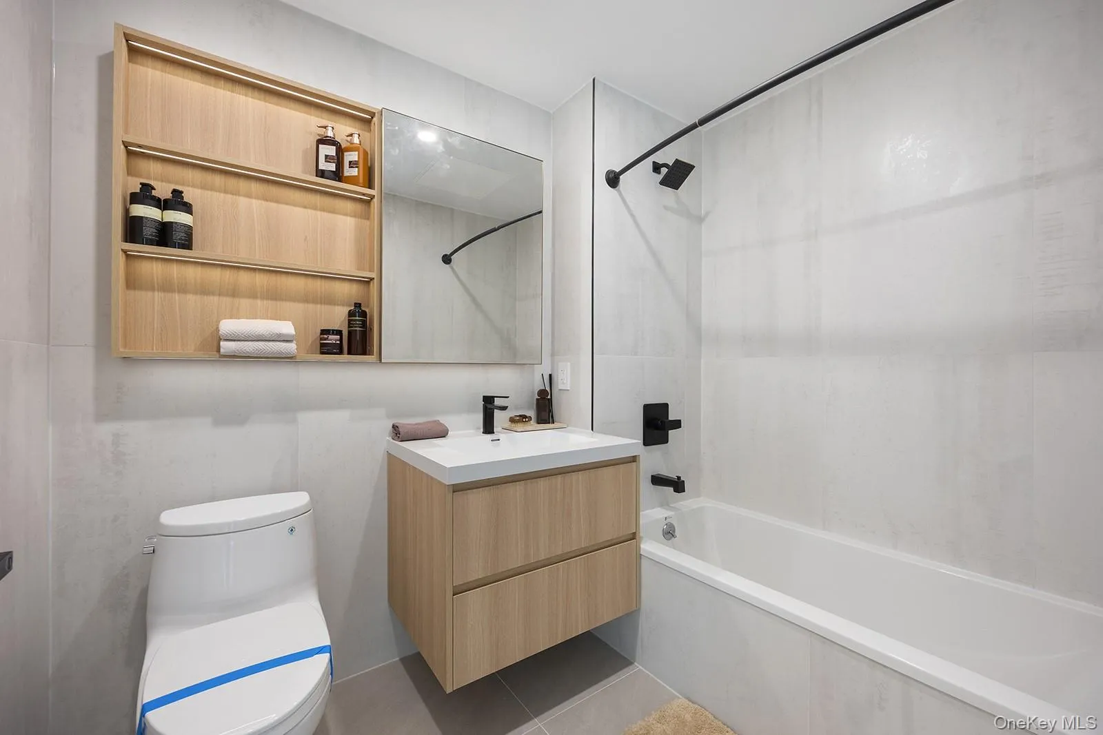 Full bathroom with vanity, shower combination, and light tile patterned floors Full bathroom with vanity, shower combination, and light tile patterned floors