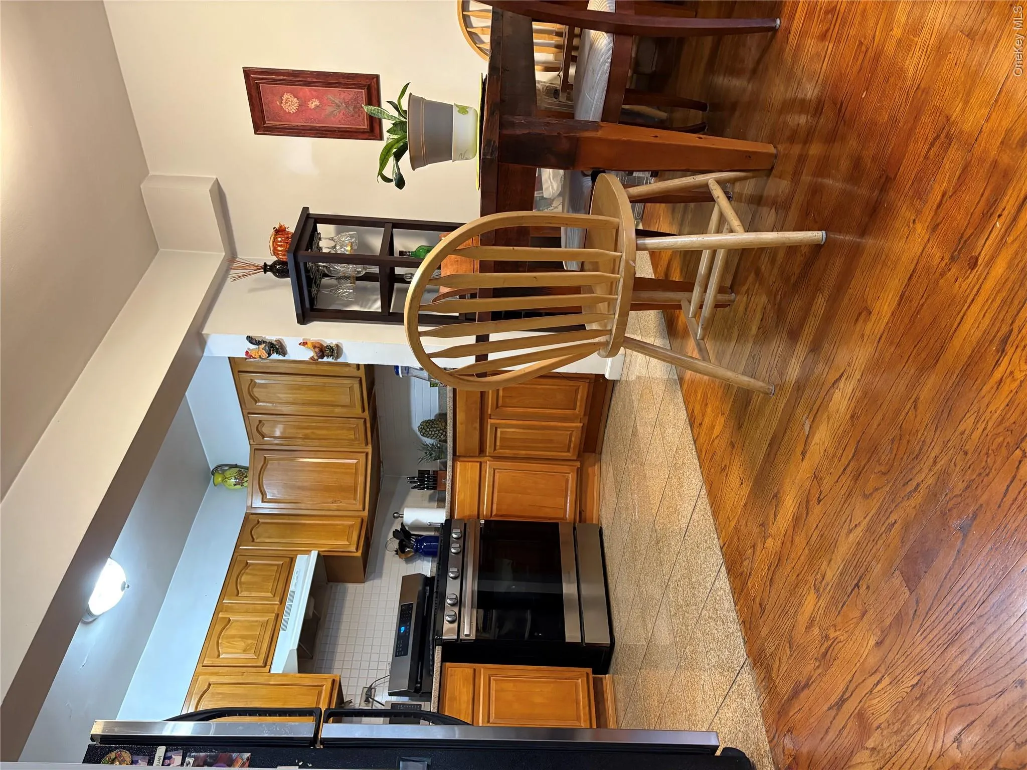 Kitchen with brown cabinets, range, range hood, dark countertops, and refrigerator Kitchen with brown cabinets, range, range hood, dark countertops, and refrigerator