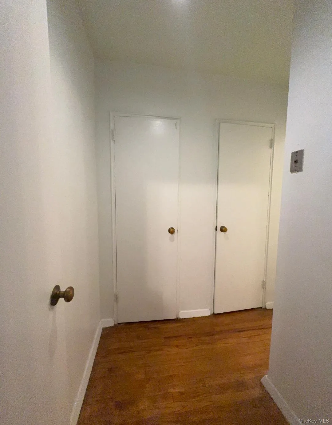 Corridor with dark wood finished floors and baseboards Corridor with dark wood finished floors and baseboards
