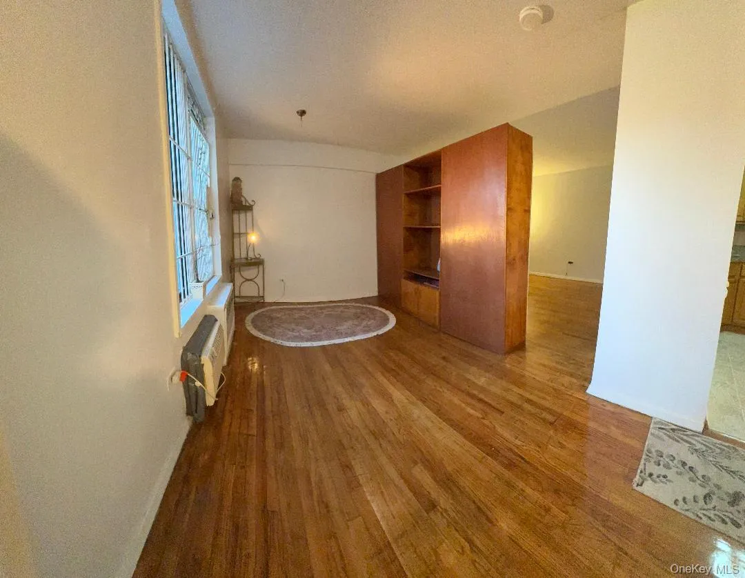 Unfurnished living room featuring dark wood finished floors and baseboards Unfurnished living room featuring dark wood finished floors and baseboards