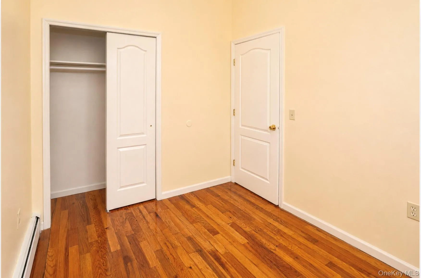 Warm-toned wood-finish flooring complements light-colored walls. Warm-toned wood-finish flooring complements light-colored walls.