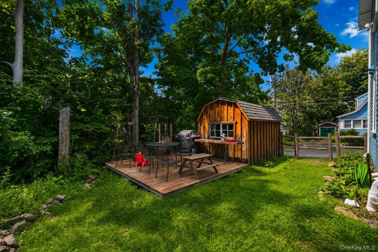 Wood-sided shed with a shingled roof, accompanied by a wooden deck Wood-sided shed with a shingled roof, accompanied by a wooden deck