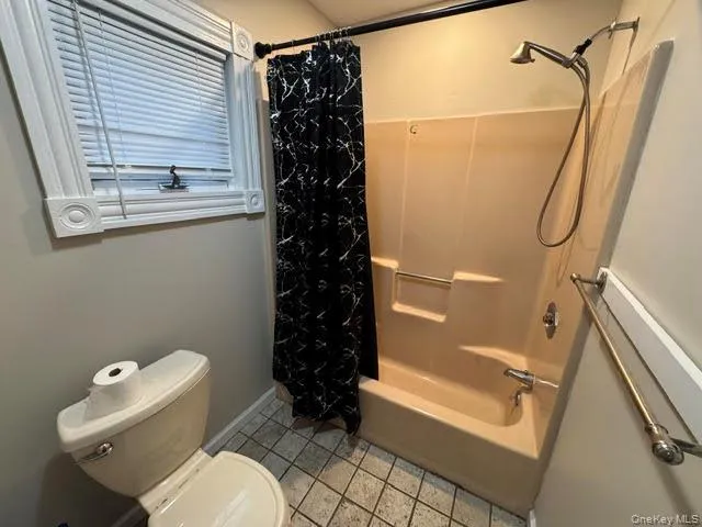 View of the tub and the window in the bathroom. View of the tub and the window in the bathroom.