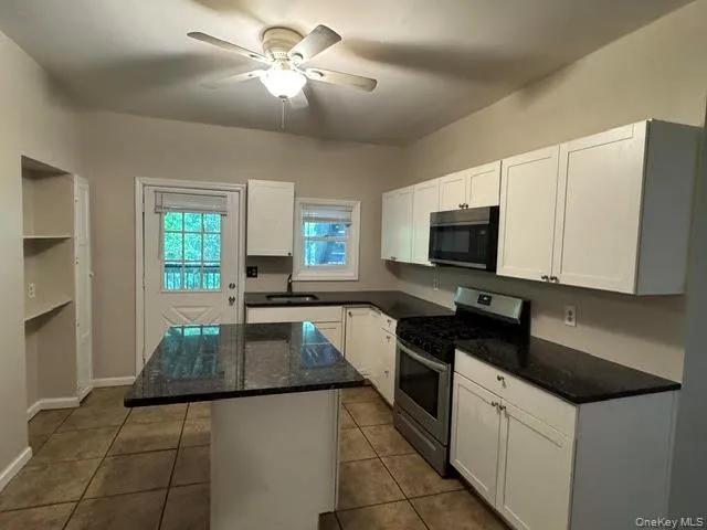 View of the kitchen with the island, ceiling light and the ceiling fan. View of the kitchen with the island, ceiling light and the ceiling fan.