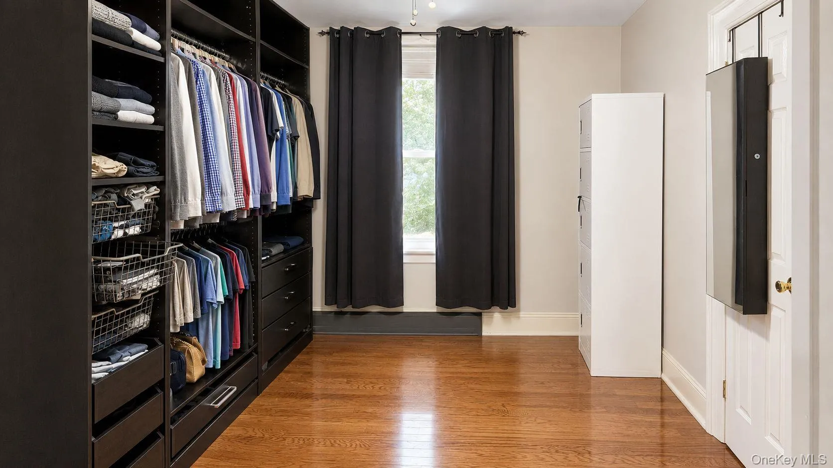 Bedroom but Removable Custom dark-finish built-in closet system with hanging rods, shelving, and drawer storage Bedroom but Removable Custom dark-finish built-in closet system with hanging rods, shelving, and drawer storage