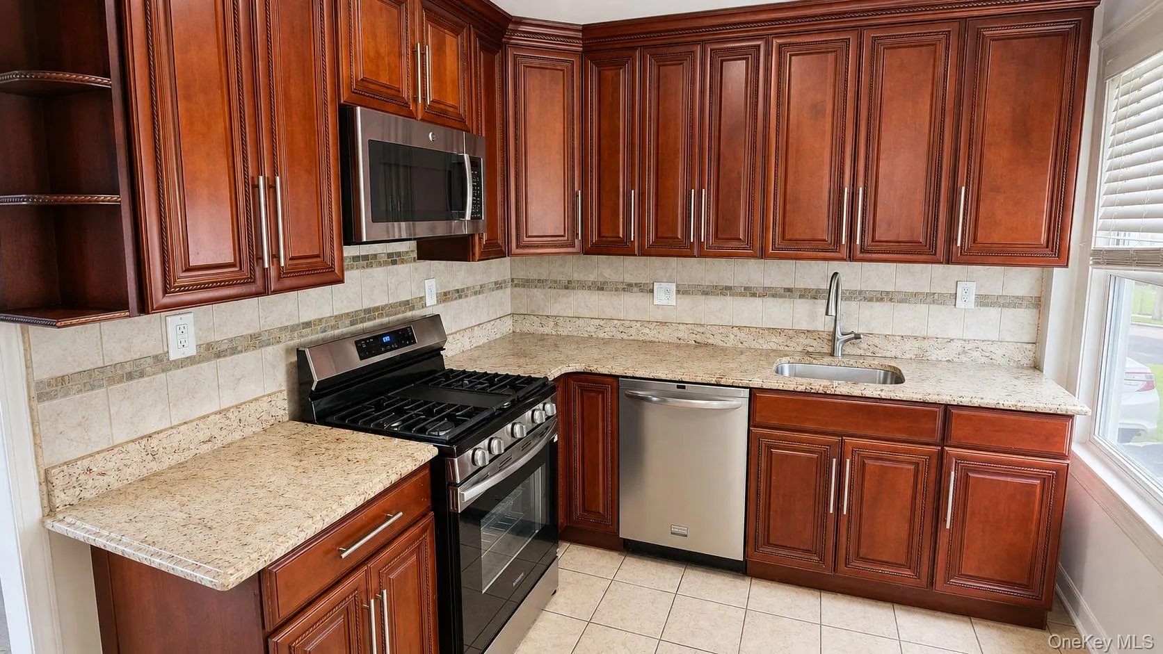 Kitchen featuring extensive wood cabinetry with modern hardware, stone countertops, a tile backsplash, and stainless steel appliances Kitchen featuring extensive wood cabinetry with modern hardware, stone countertops, a tile backsplash, and stainless steel appliances