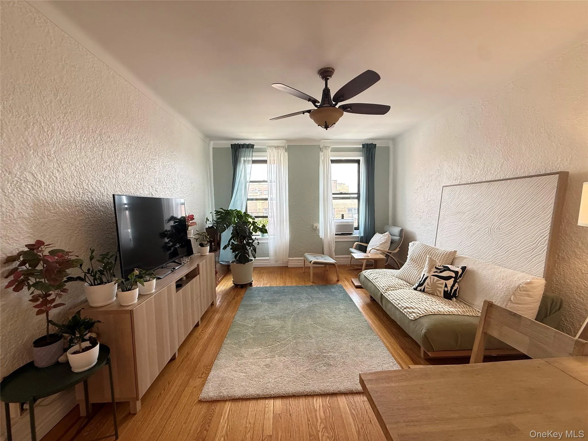 Hardwood flooring, textured wall finish, and a ceiling fan with integrated lighting. 1940 Classic Post war Architecture Hardwood flooring, textured wall finish, and a ceiling fan with integrated lighting. 1940 Classic Post war Architecture